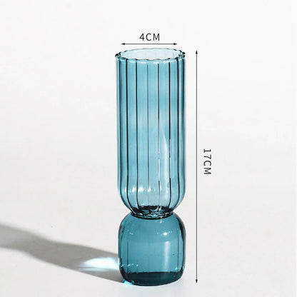 Five colorful Nordic glass sphere vases arranged in a row on a floating shelf
