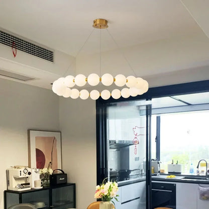 Bead strand chandelier in warm 3000K light on a chrome iron ring