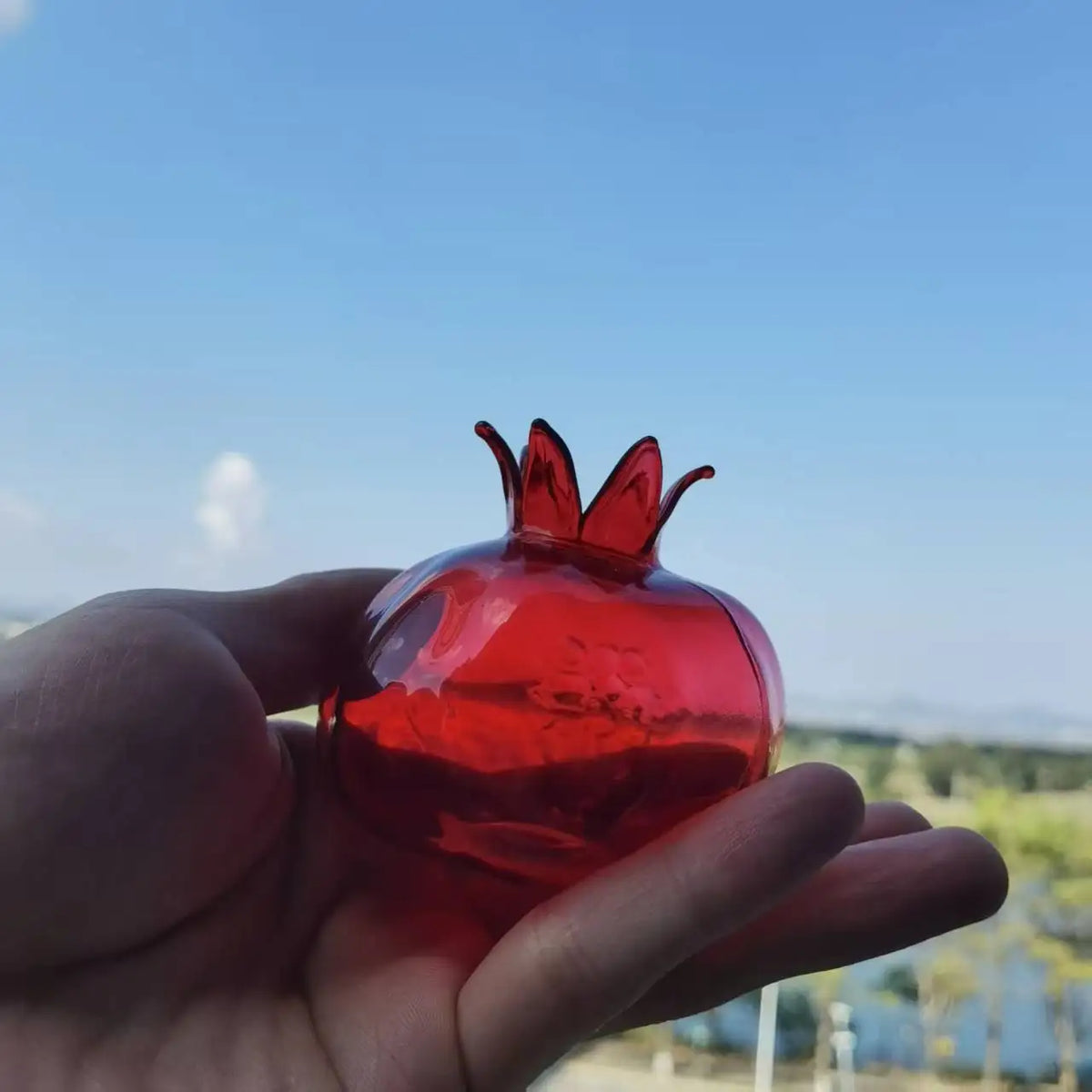 Small red pomegranate hand-blown glass vase close-up detail view