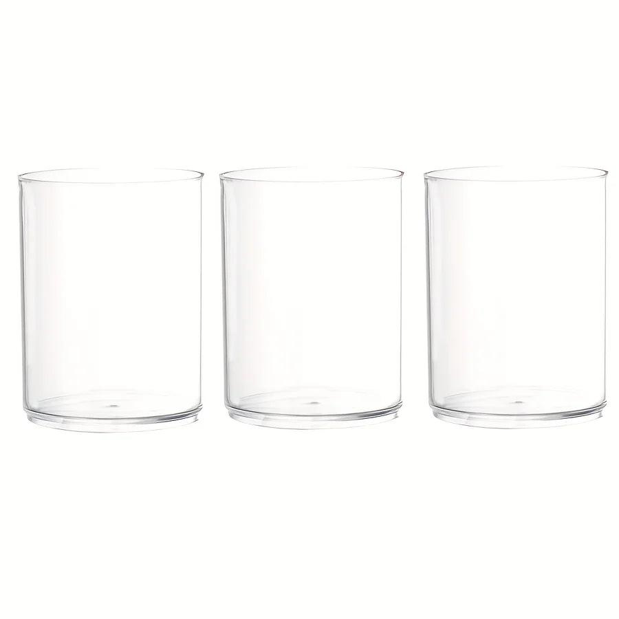 Three clear acrylic cylinder vases with taper candles for festive table display