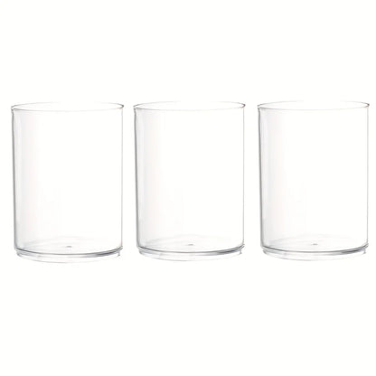Three clear acrylic cylinder vases with taper candles for festive table display