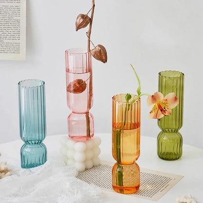 Transparent Nordic glass sphere vase on marble dining table with single stem flower