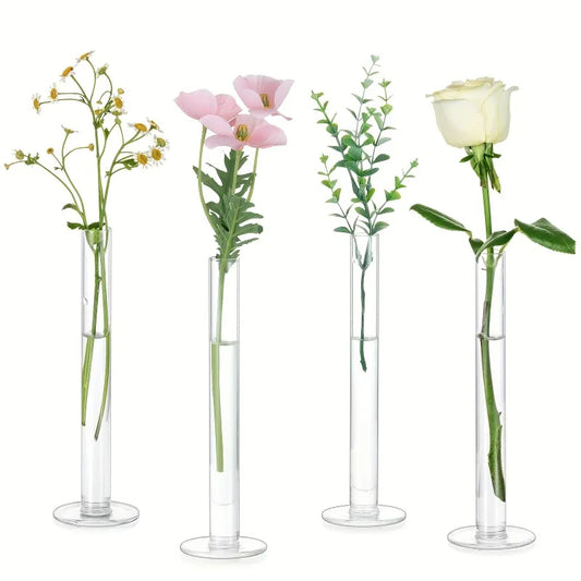 Set of four slim clear glass cylinder vases arranged on a Scandi dining table