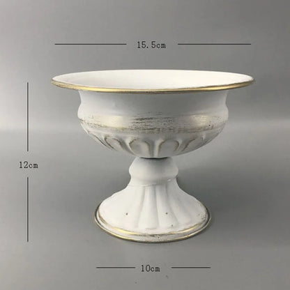 Gold vase candle holder with white taper candle on blush linen table