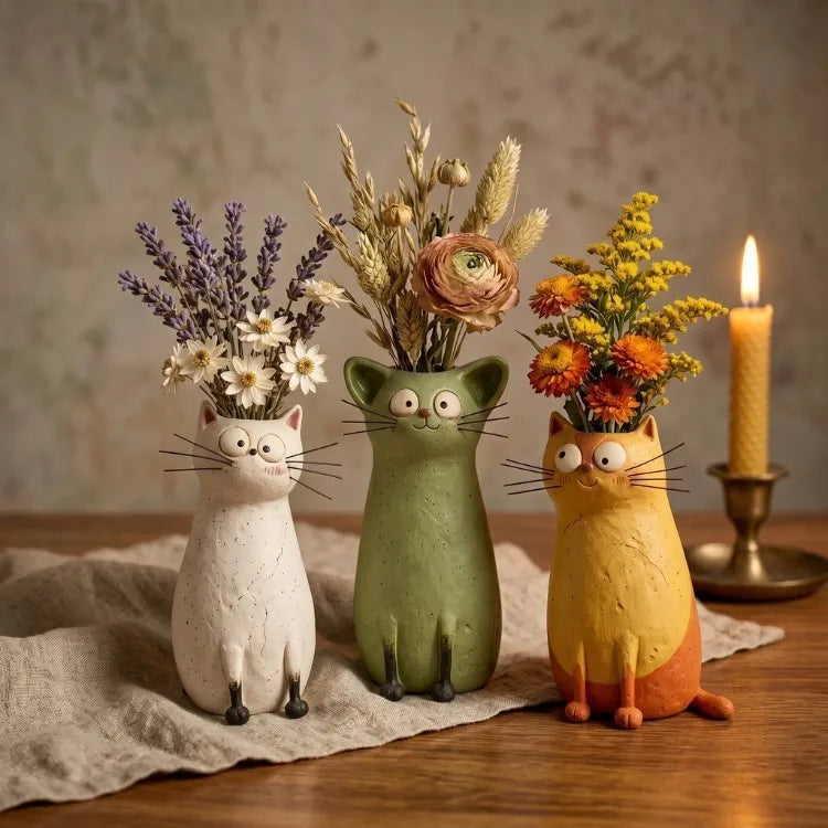 Yellow resin kitten-shaped bud vase holding single white flower stem against plain background