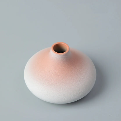Japanese matte black ceramic vase with dried eucalyptus on wooden shelf