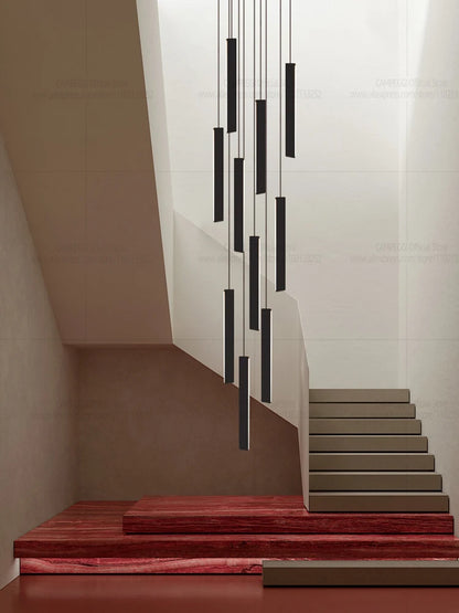 Black aluminum rod chandelier lit in warm light down a stairwell