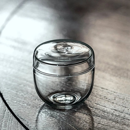 Glass moss terrarium bottle styled on eclectic home shelf display