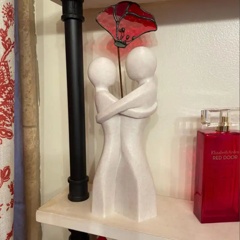 Red ceramic heart-shaped embrace vase for Valentine's Day gift display on white surface