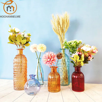 Red glass terrarium vase with single flower stem on modern dining console