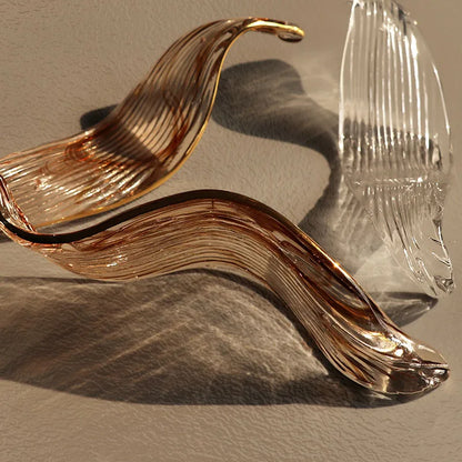 Glass shade and plated metal bar detail on the linear chandelier
