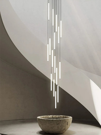 Strip chandelier lit in warm light down a duplex stairwell