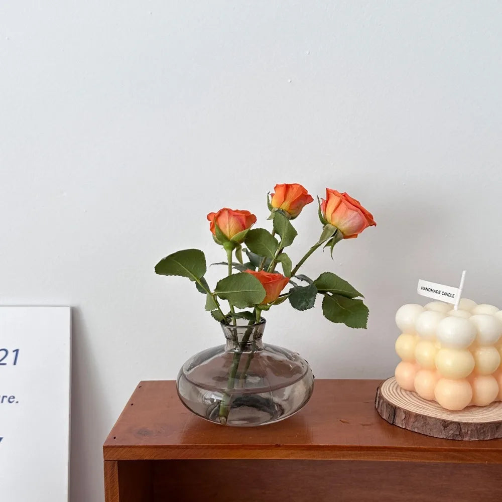 Transparent C style mini glass vase on home office wooden desktop