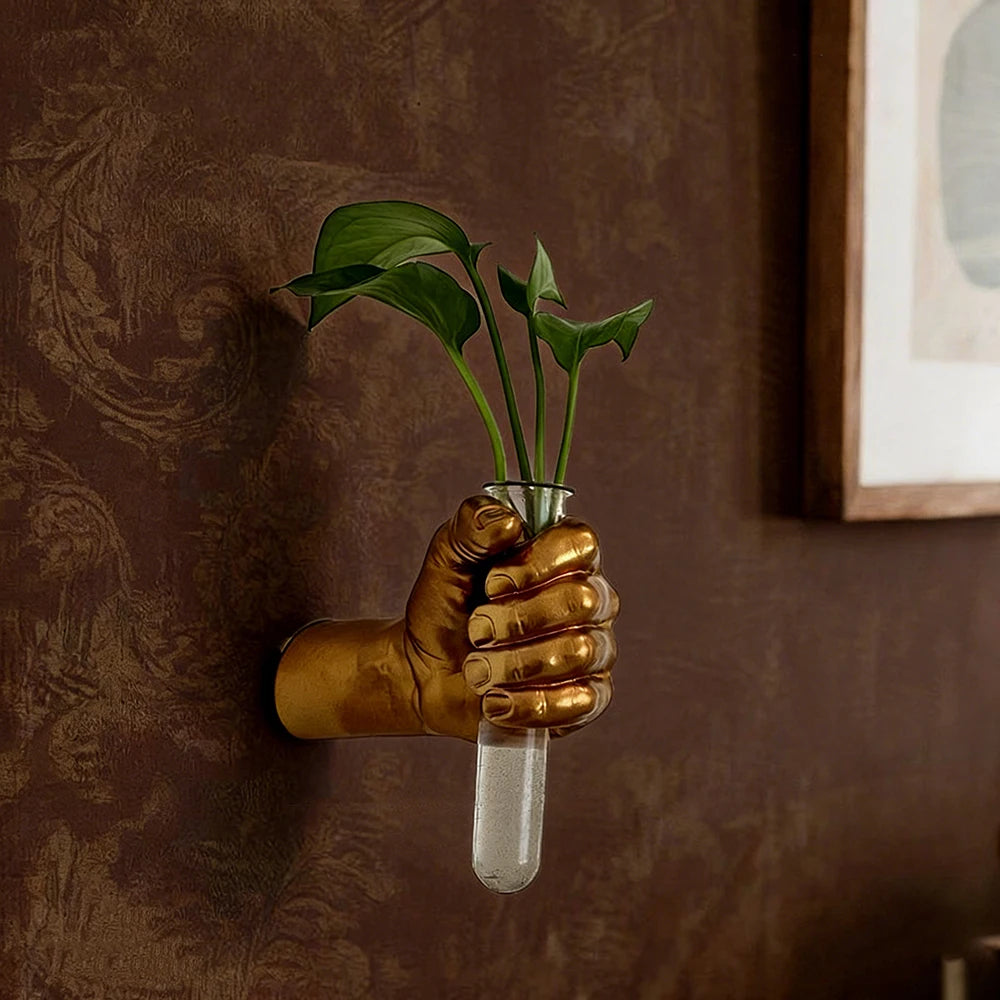 Resin boxer fist wall vase mounted on white wall gripping small flower vessel