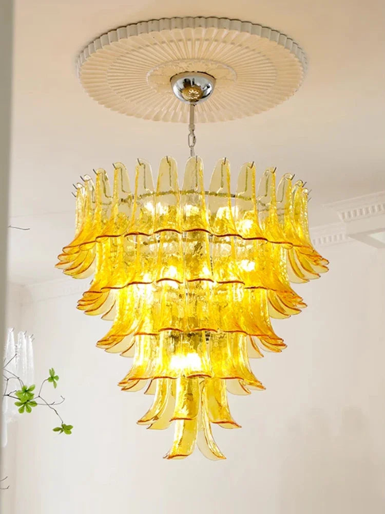 Floral chandelier casting light up and down through tinted stained glass