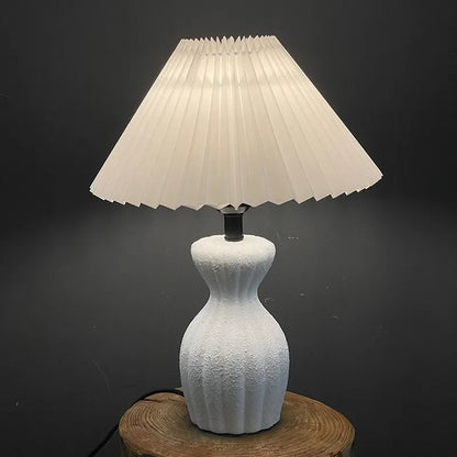 White ceramic table lamp with cloth shade on bedroom study desk