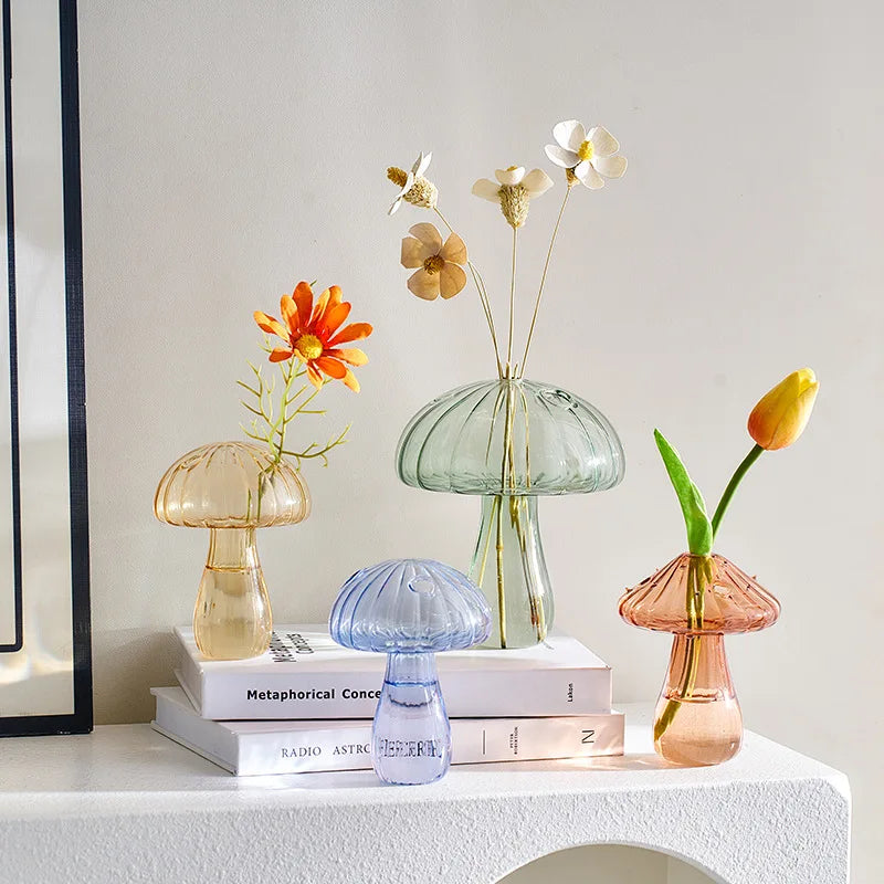 Transparent mini mushroom glass vase holding small plant cutting on shelf