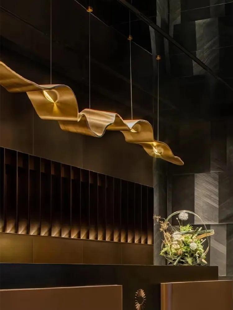 Brass finish linear chandelier with glowing ring shaped heads