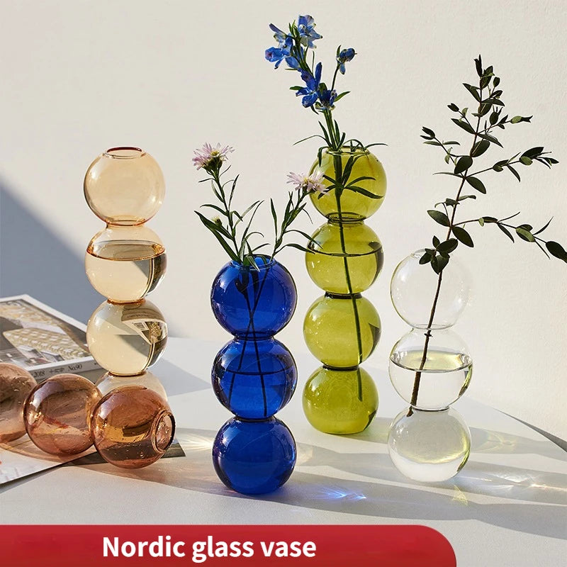 Smaller orange-S geometric glass terrarium vase with air plant display on desk surface