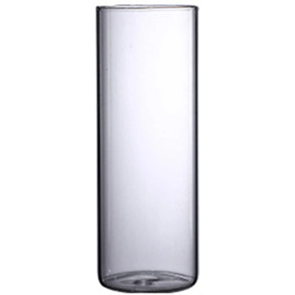 Glass cylinder vase flat lay on grey concrete surface with fresh eucalyptus sprig