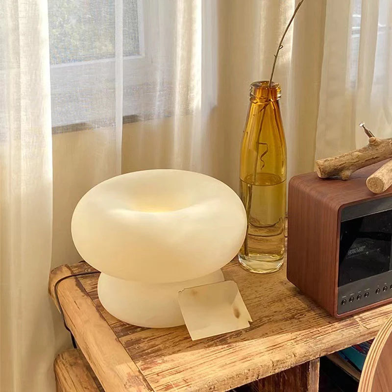 Art Deco glass table lamp illuminated in neutral white light, angled side view