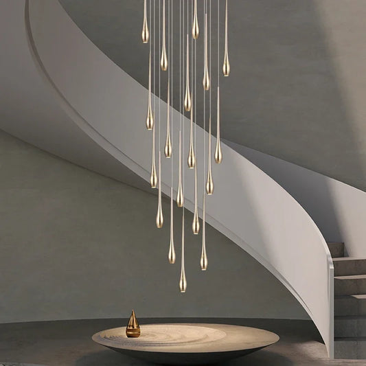 Gold plated staircase chandelier with gilded arms stepping down a void
