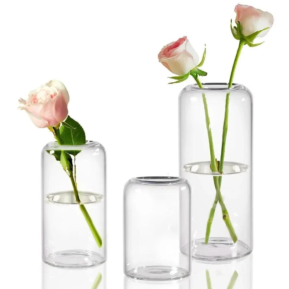 Simple glass hydroponic vase with fresh peonies on marble counter surface