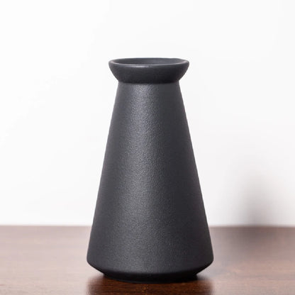 Frosted ceramic bud vase style C on a Japandi-inspired desk with pebbles and book