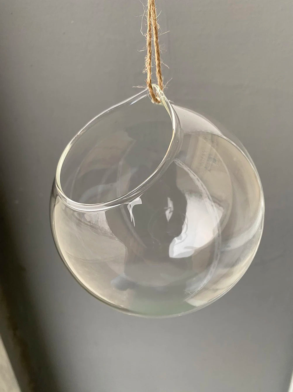 Glass ball hanging terrarium vase suspended with macrame cord in boho room