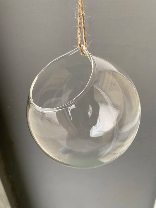 Glass ball hanging terrarium vase suspended with macrame cord in boho room