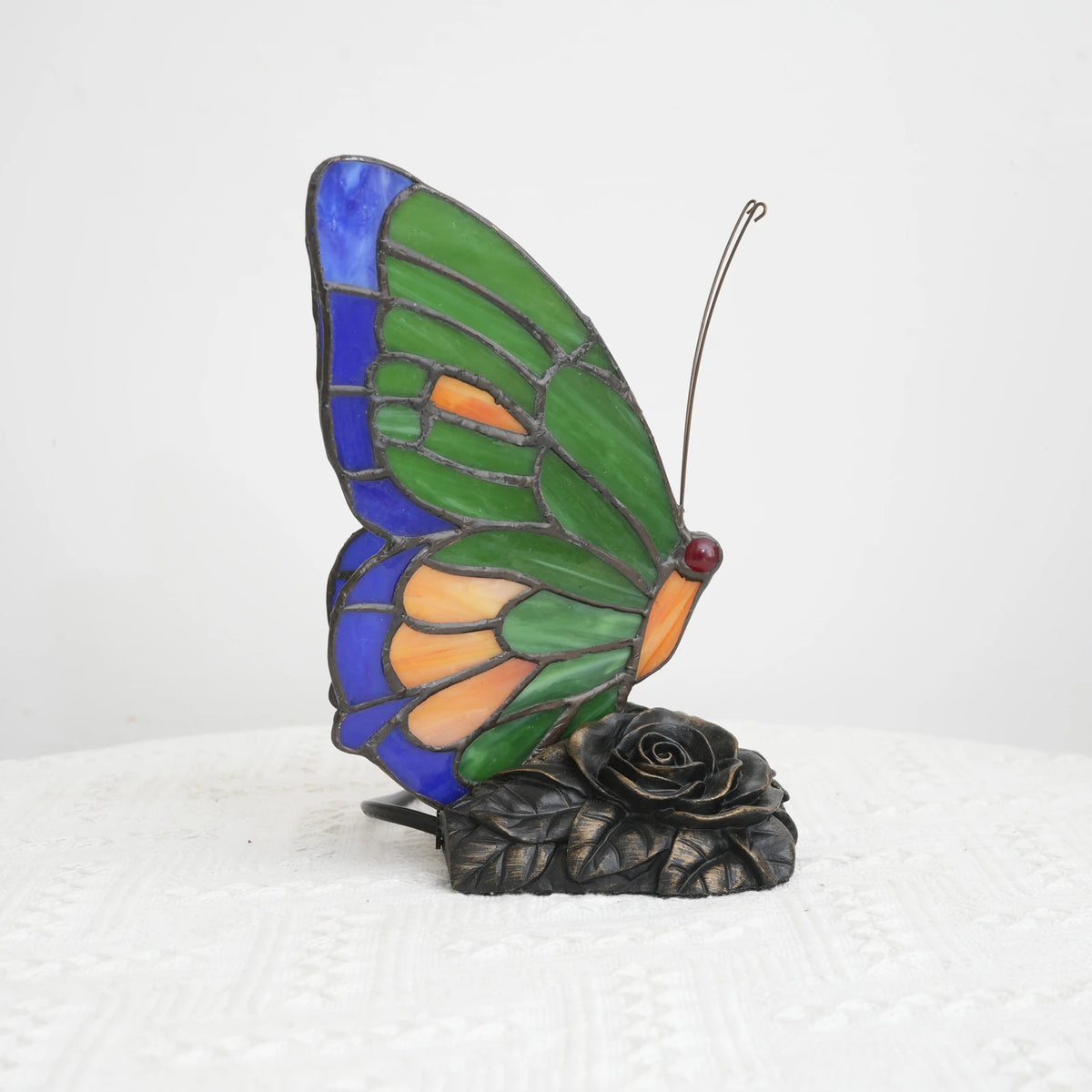 Handmade green butterfly lamp switched off showing glass colours in daylight