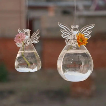 Close-up of angel figurine form in clear glass hanging flower vase