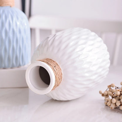 White ripple-textured plastic Nordic vase holding dried botanical stems on desk