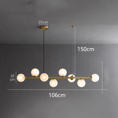 Linear iron chandelier with glass shades shown unlit against a wall