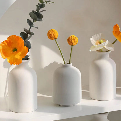 Three beige boho ceramic vases in varying heights as bookshelf display