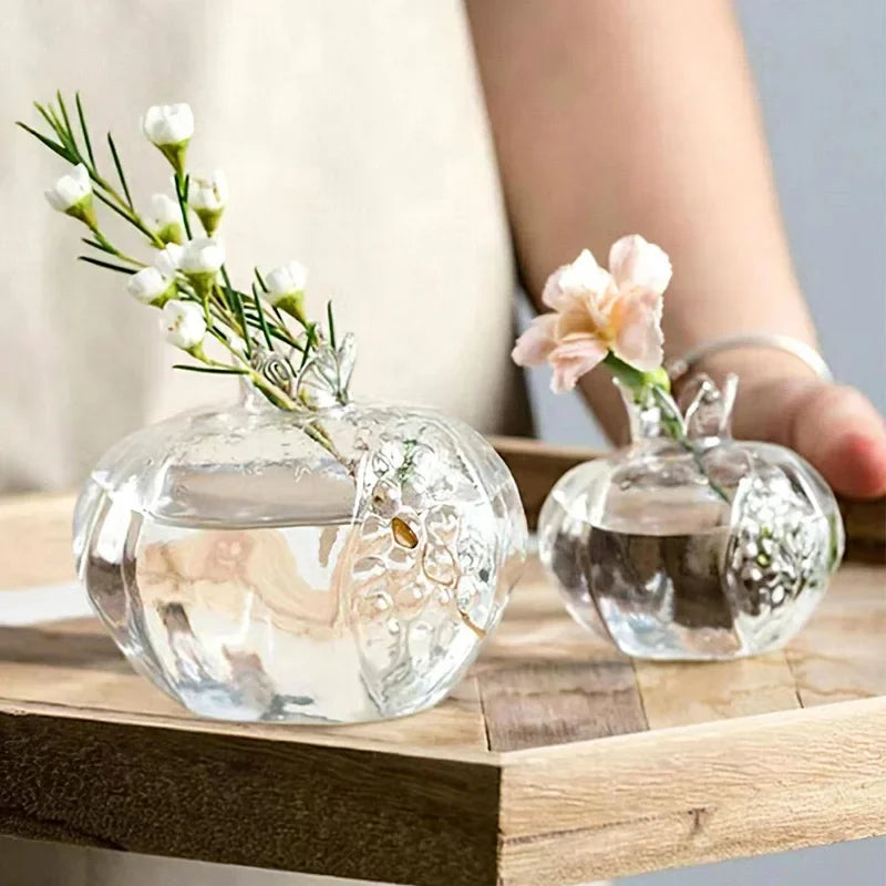 Transparent glass pomegranate shaped vase against light background