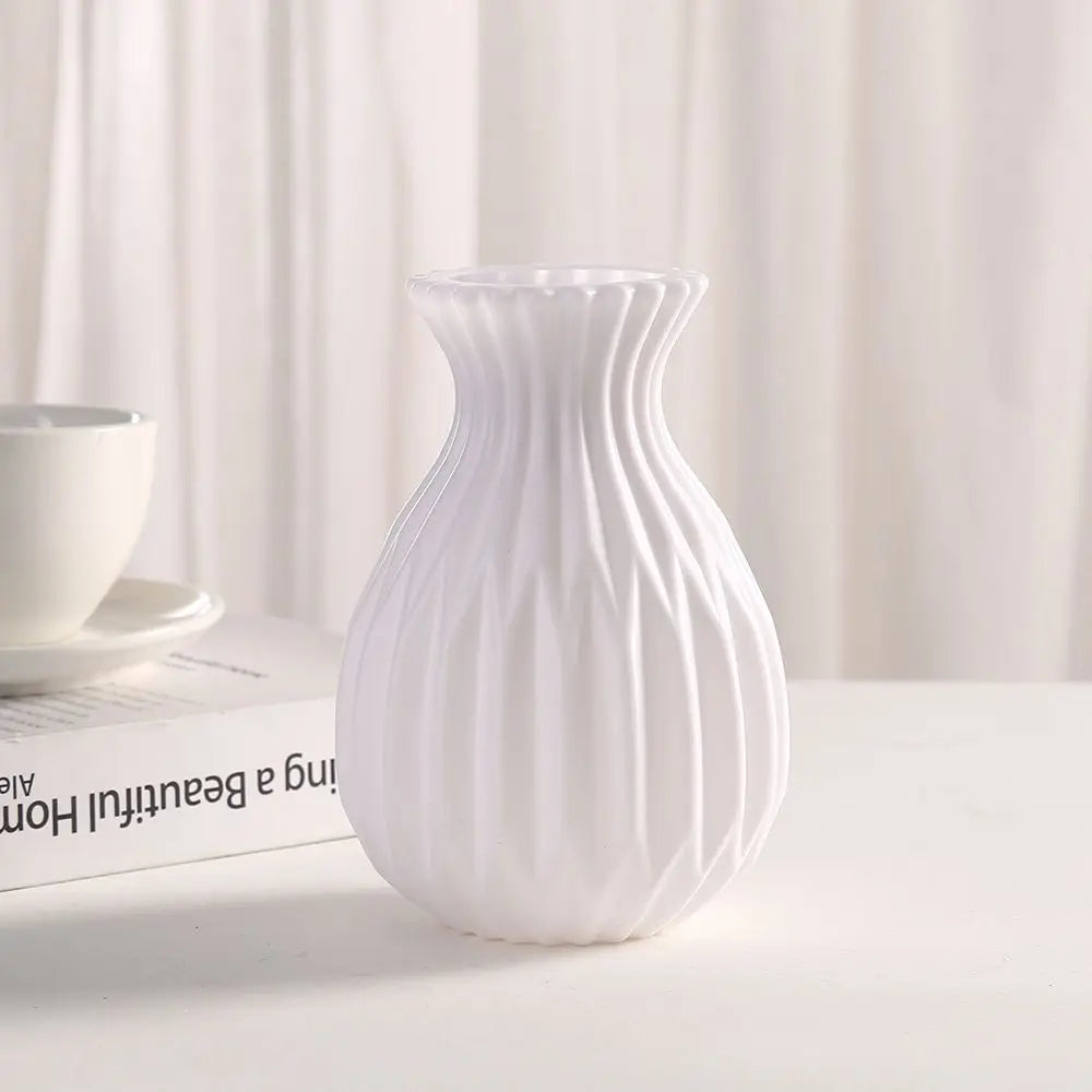White plastic imitation ceramic vase with small succulent for minimalist desk display