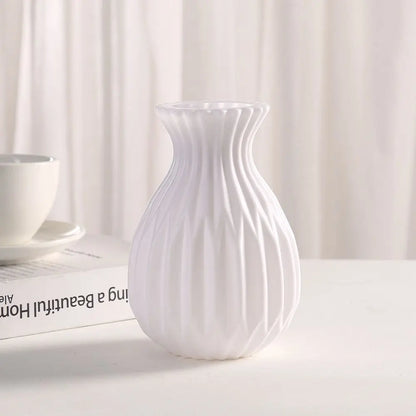 White plastic imitation ceramic vase with small succulent for minimalist desk display