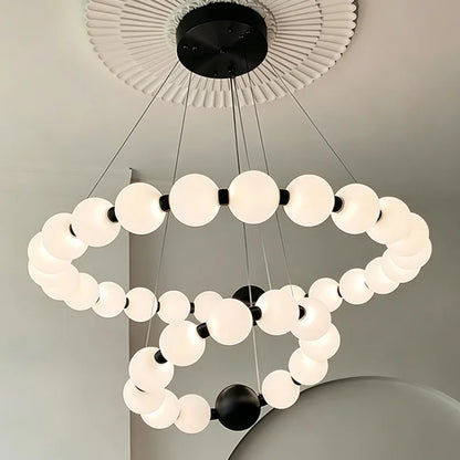 Gold ring chandelier lit in warm white above a dining table