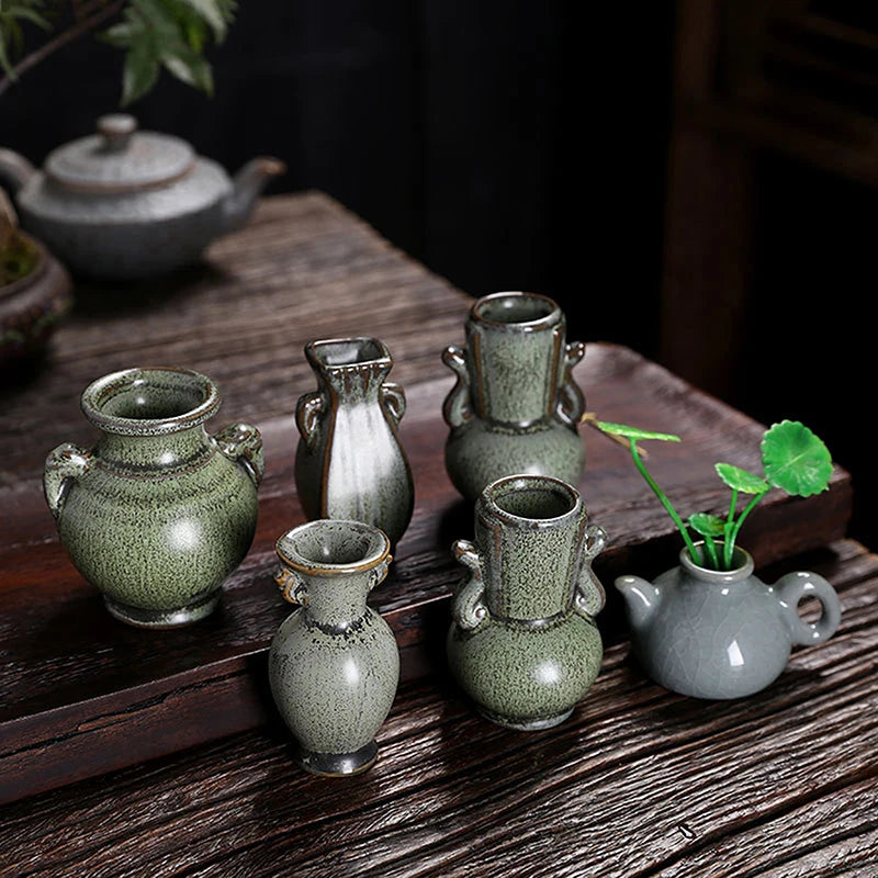Green retro ceramic miniature vase on wooden tabletop