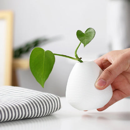 Close-up of smooth matte black ceramic glaze on small decorative bud vase surface