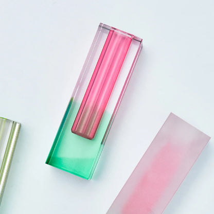 Short frosted pink-yellow acrylic pillar vase on a minimalist marble surface