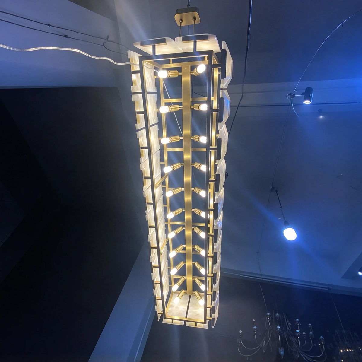 Black frame alabaster chandelier giving a continuous band of warm light