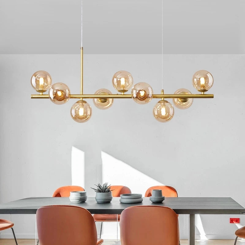 Cognac glass shades on a gold brushed nickel linear chandelier bar