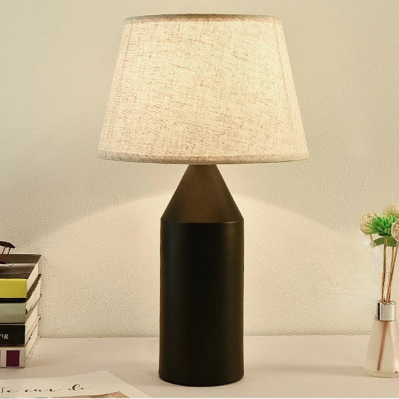 White minimalist table lamp illuminated on study desk in clean room