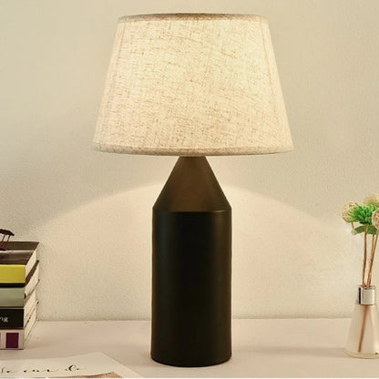 White minimalist table lamp illuminated on study desk in clean room