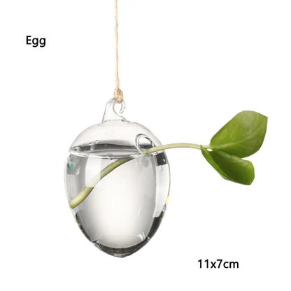 Hanging glass ball vases in multiple shapes along a driftwood branch display