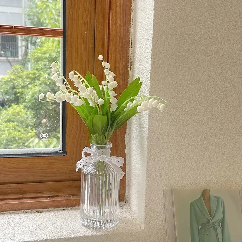 Medium-sized Nordic glass bottle vase with fresh flowers on modern shelf