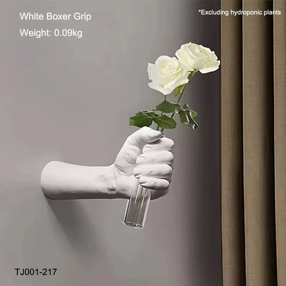 Resin wall vase in boxer pose styled next to framed prints on feature wall