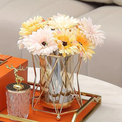 Gold iron geometric vase styled with tall tropical stems in a modern living room